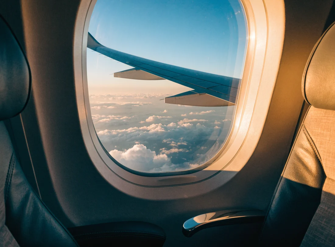 Accomy travel journal beside an airplane window